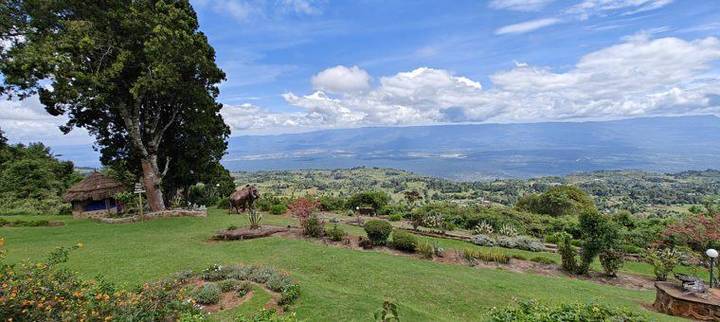 Vista sobre o vale a partir de um jardim no alto da escarpa, sob um céu carregado de nuvens.