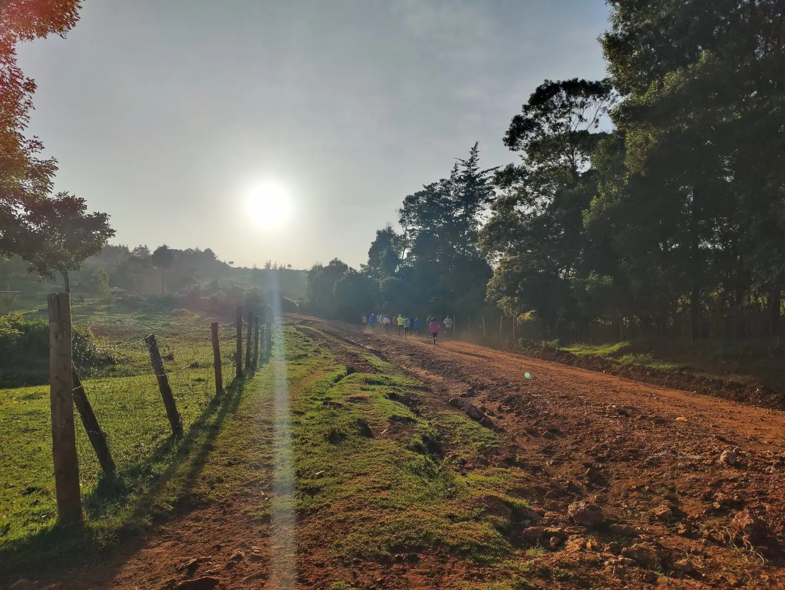 Nascer do sol numa estrada de terra vermelha: os primeiros corredores do dia já estão a treinar.